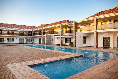 Matola的住宿－Platinum Lodge Matola，一座建筑的庭院中的游泳池
