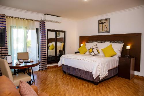 ein Schlafzimmer mit einem großen Bett mit gelben Kissen in der Unterkunft Platinum Lodge Matola in Matola