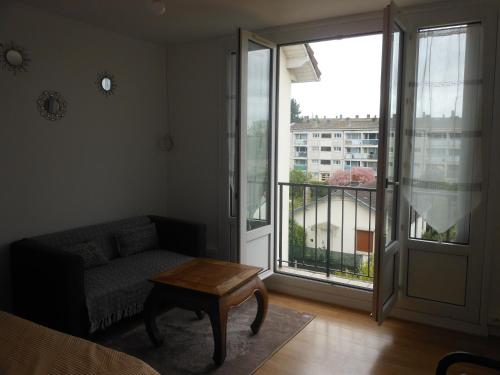 d'un salon avec un canapé et une table ainsi que d'un balcon. dans l'établissement appartement entier 2 chambres, à Beauvais
