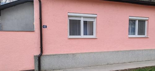 a pink building with two windows on the side of it at Apartman Stanković in Odžaci