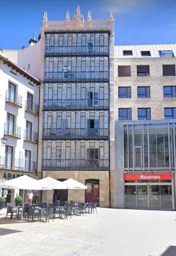 un edificio con mesas y sombrillas delante en Rincón en edificio Modernista en centro de Soria, en Soria
