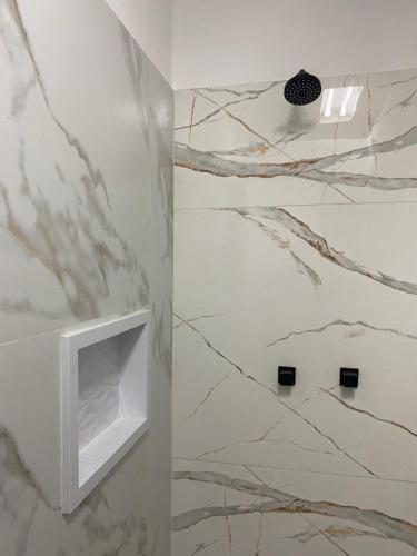 a bathroom with a white tv on a wall at Trem Chic in Belo Horizonte