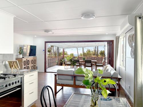 a kitchen and living room with a couch and a table at Vila Paus Satu - Ocean Views Hervey Bay in Hervey Bay