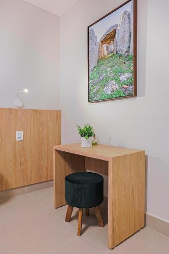 a desk with a chair and a painting on the wall at Pousada e Adega Lapa do Lobo in Conservatória