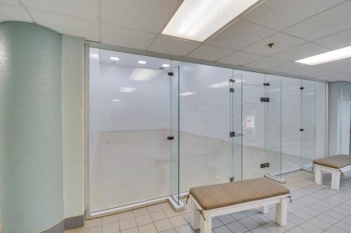a glass shower in a room with a bench at Beachfront Orange Beach Condo with Ocean Views! in Orange Beach