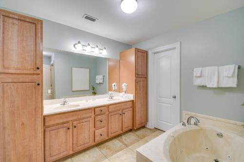a bathroom with two sinks and a bath tub at Oceanfront Orange Beach Condo with View and Pool! in Orange Beach