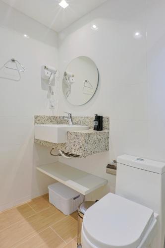 a bathroom with a toilet and a sink and a mirror at Pousada e Adega Lapa do Lobo in Conservatória