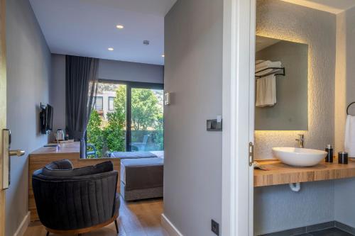 a bathroom with a sink and a chair in a room at Gündoğan Suites in Bodrum City