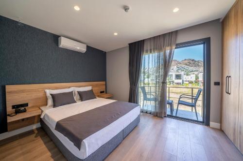 1 dormitorio con 1 cama grande y balcón en Gündoğan Suites, en Bodrum City