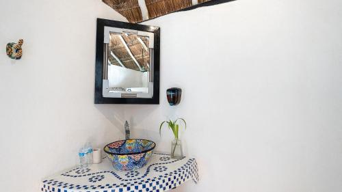 een badkamer met een kom op een tafel met een spiegel bij Chancabañita Tulum in Tulum