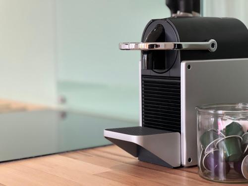 un four-grille-pain installé au-dessus d'une table en bois dans l'établissement Appartement Gordon Smith, en plein centre, 4 pers, à Sainte-Mère-Église