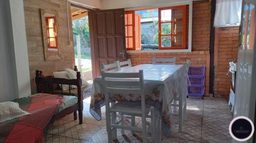 uma sala de jantar com mesa e cadeiras em Chalé no Farol de Santa Marta em Laguna