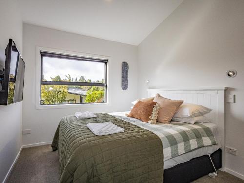 a bedroom with a large bed with a window at Findlay Chalet - National Park Holiday Home in National Park