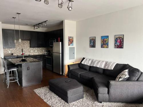 a living room with a couch and a kitchen at BEAUTIFUL STUDIO 7MIN FROM THE GALLERIA MALL in Houston