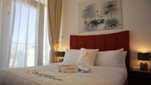 een slaapkamer met een groot bed en een groot raam bij Wanderlust 2BR Apartment in Abu Dhabi