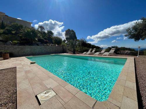 einen Pool mit blauem Wasser im Hof in der Unterkunft Studio 1 avec piscine & vue sur la baie d'Ajaccio in Alata