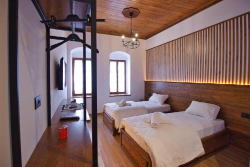 1 dormitorio con 2 camas y espejo en Grey Stone, en Gjirokastra