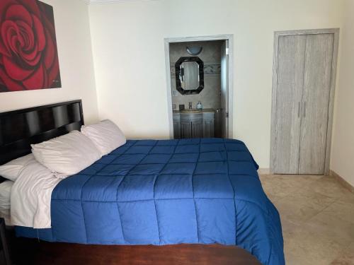 1 dormitorio con edredón azul en la cama en Las Olas Grand, en Divisadero