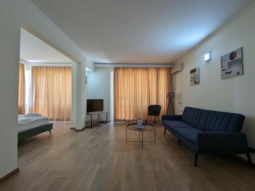 een woonkamer met een blauwe bank en een televisie bij Hotel Tsiskari in Ianet'i