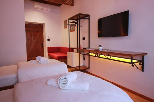 a room with two beds and a flat screen tv at Grey Stone in Gjirokastër
