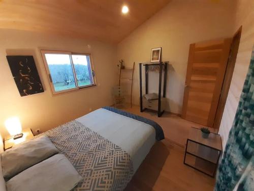 une chambre avec un grand lit et une fenêtre dans l'établissement Maison Piscine Naturelle, à Sainte-Croix-de-Beaumont