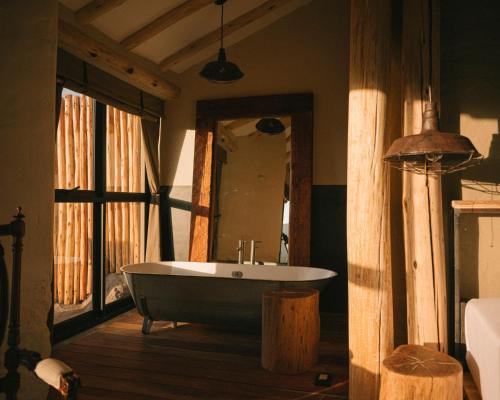 bañera en una habitación con espejo grande en PUQIO en Yanque