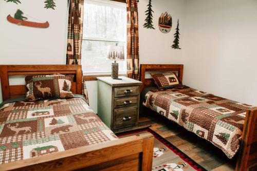 een slaapkamer met 2 bedden, een dressoir en een raam bij Luxury Mountain Getaway in Pickens