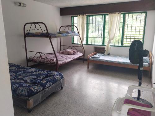 a room with two bunk beds and two windows at QUINTA MARIA LUISA in Melgar