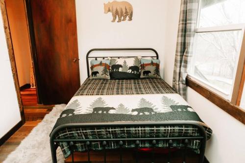 a small bedroom with a bed with a blanket at Luxury Mountain Getaway in Pickens