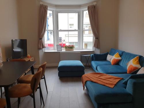 a living room with a blue couch and a table at Clarence House in Brighton & Hove