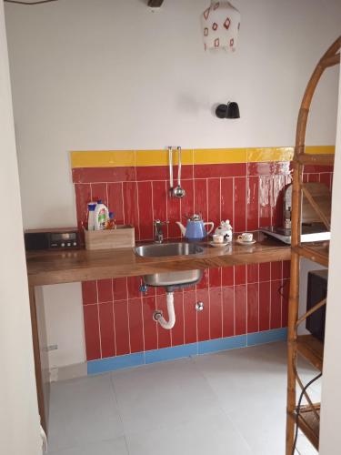 a kitchen with a sink and red tiles at Casetta capodimonte in Naples