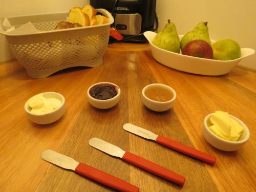 a wooden counter topped with utensils and bowls of food at Refúgio da Montanha in Urubici