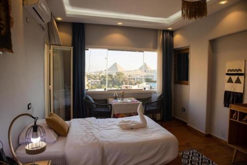 a bedroom with a bed with a view of the pyramids at Three pyramids view INN in Cairo