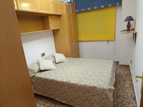 Cette petite chambre comprend un lit et une porte jaune. dans l'établissement Torrellano, à Torrellano
