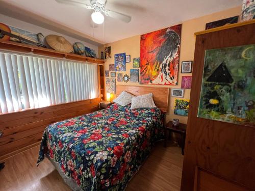 a bedroom with a bed with a colorful comforter at Miami Bungalow Oasis near Everglades & The Keys in Cutler Bay