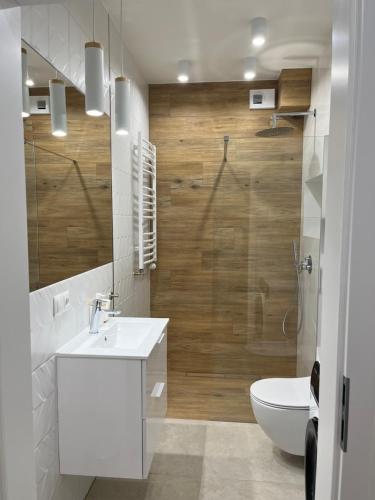 a bathroom with a white sink and a toilet at Apartament Chodkiewicza 64 in Bydgoszcz