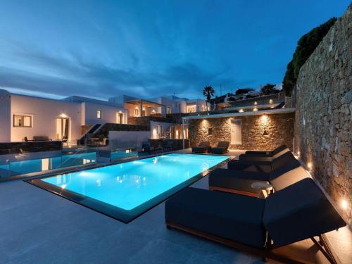 une villa avec une piscine la nuit dans l'établissement Stunning Oceanview Mykonos Villa | 5 Bedrooms | Villa Perseus | Amazing Location Overlooking Sea & Private Pool | Faros, à Fanari