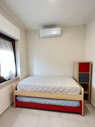 a small bedroom with a bed and a window at Red & Blue apartments in Termoli
