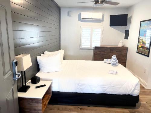 a bedroom with a white bed with a wooden headboard at Devon Shores in Clearwater Beach