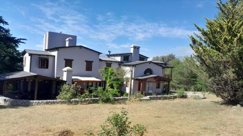 a large white house with a yard at Yanasuspa Huasin & Sol del Pilar in Tafí del Valle