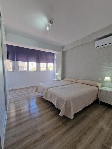 a large bedroom with a large bed and wooden floors at Virgen de Luján Triana in Seville
