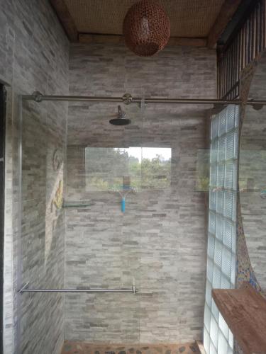 a shower in a room with a stone wall at Reserva Natural Zarandá in Pereira