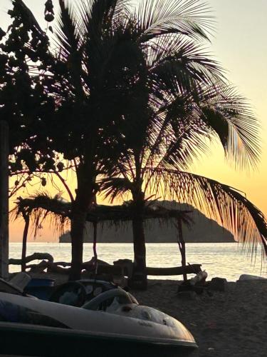 a couple of palm trees on a sandy beach at Casa Moka Azul in La Peñita de Jaltemba