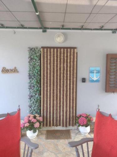 a room with two chairs and a door with flowers at Apartment AMare in Šibenik