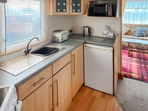 Il comprend une petite cuisine équipée d'un évier et d'un lave-vaisselle. dans l'établissement Carnaby - Uk47074, à South Chard