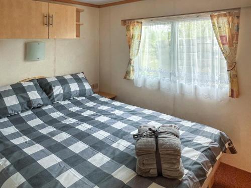 - une chambre avec un lit bleu et blanc et une fenêtre dans l'établissement Carnaby - Uk47074, à South Chard