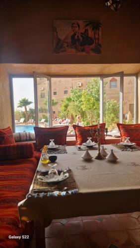 a living room with a table and a couch at Kasbah Ait BenHadda in Skoura