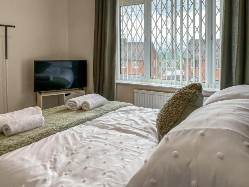 a bedroom with a bed and a tv and a window at Harris House in Staveley