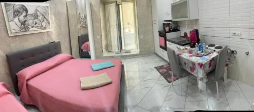 Zimmer mit einem rosa Bett und einem Tisch in der Unterkunft Casa sul muretto in Neapel