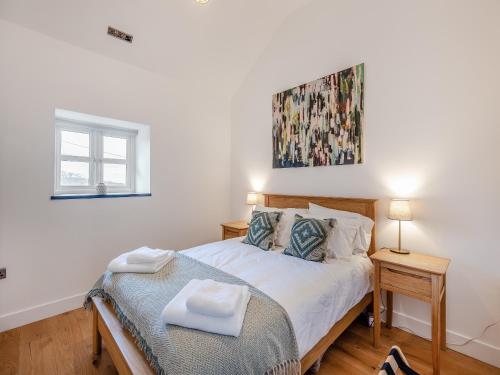 a bedroom with a bed and a painting on the wall at Y Beudy Gwydir in Trevor